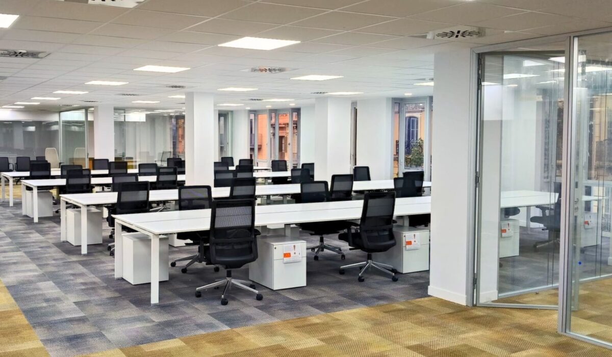 Oficinas ibertransit barcelona, cocina tipo office, despachos, sala de espera con sofa y escritorios.