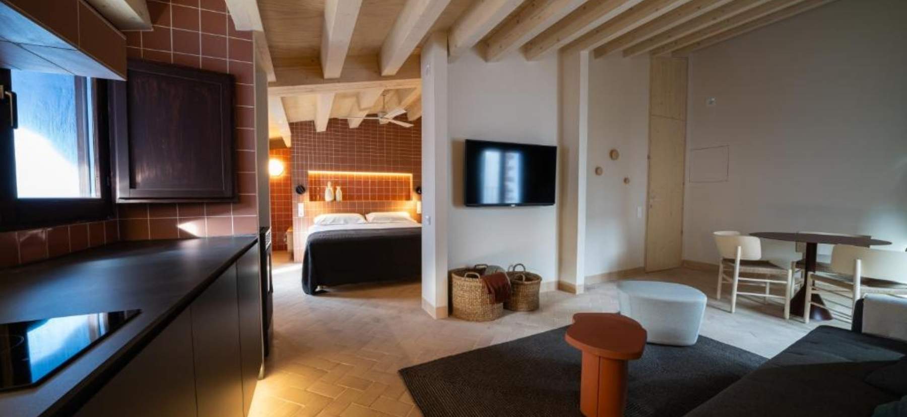 Apartamento rústico moderno con cocina integrada al salón-comedor y habitación matrimonial al lado, ideal para un ambiente acogedor.